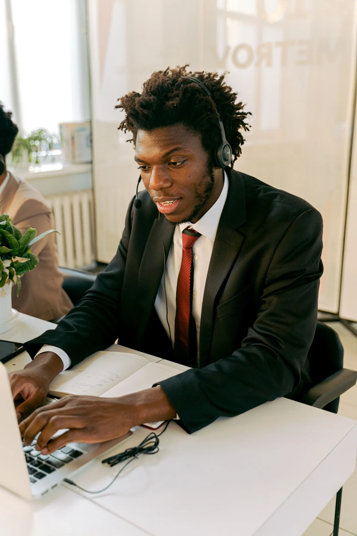 A professional using a laptop and headset